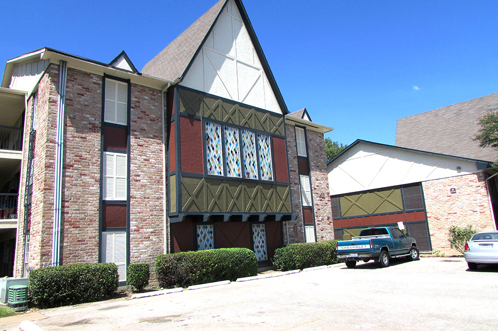 The Colony of San Marcos exterior building featuring large windows.