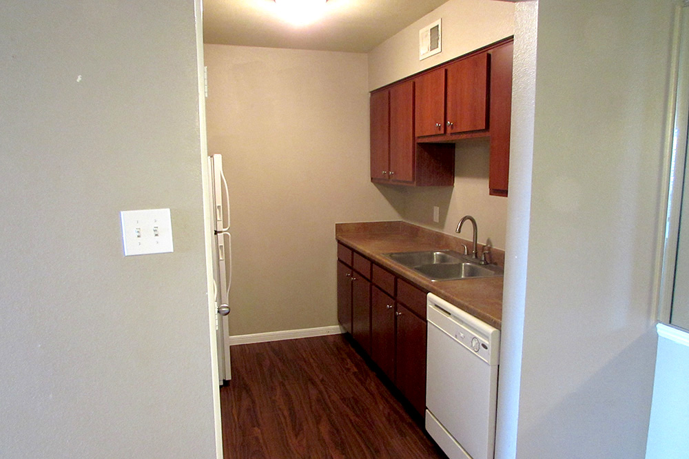 Galley-style kitchen with wood cabinets above and below the kitchen sink.