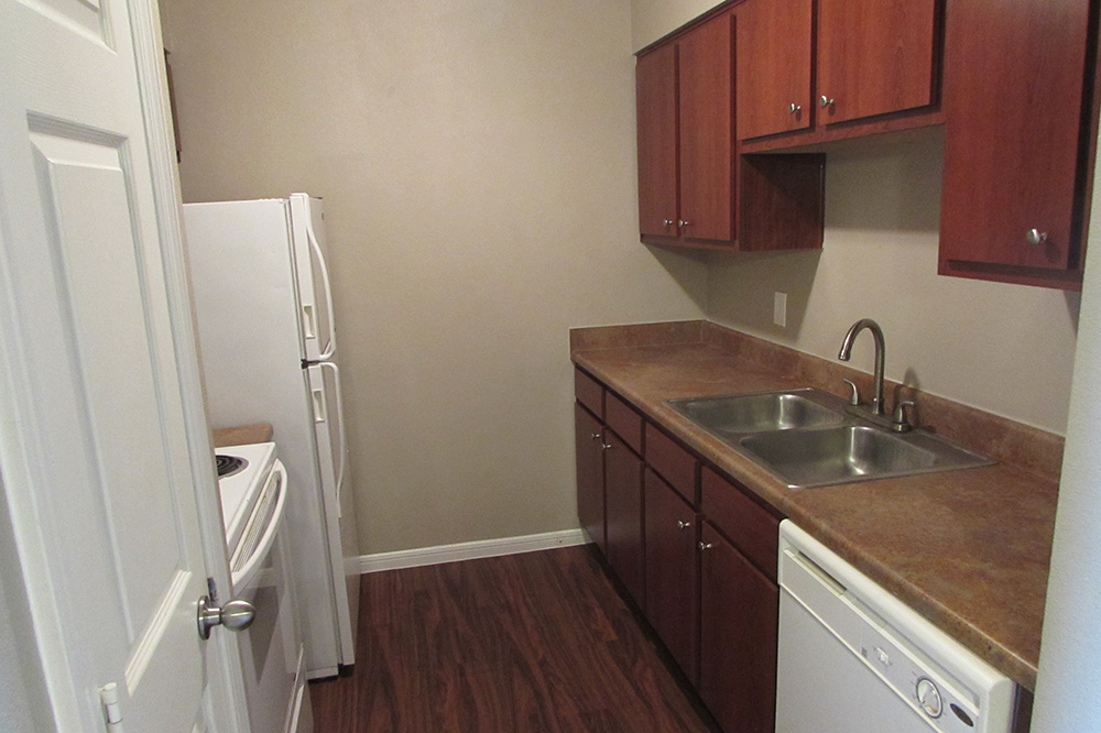 Galley-style kitchen with wood cabinets above and below the kitchen sink.