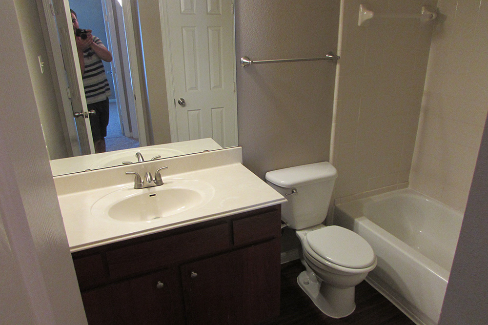 Bathroom sink, toilet, and shower and bath combo.